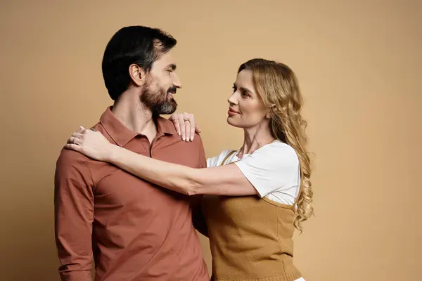 Um homem e uma mulher compartilham um momento terno, sorrindo e olhando um para o outro, irradiando afeto. — Fotografia de Stock