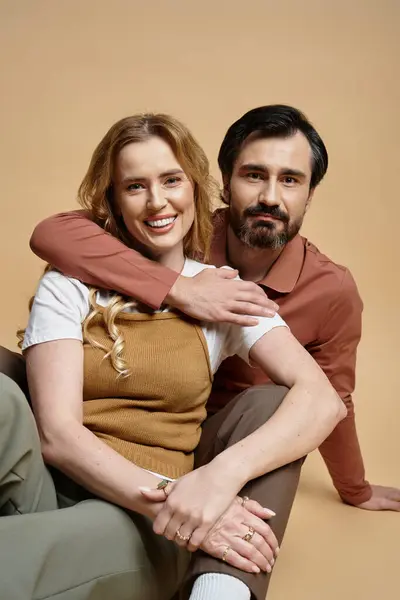 A joyful middle aged couple sits close, sharing smiles and warmth in a relaxed atmosphere. — Stock Photo