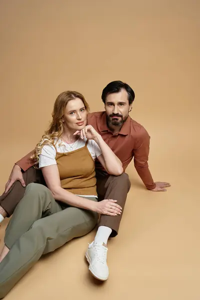 Un couple s'engage ludique dans un studio confortable tout en mettant en valeur leurs tenues à la mode. — Photo de stock