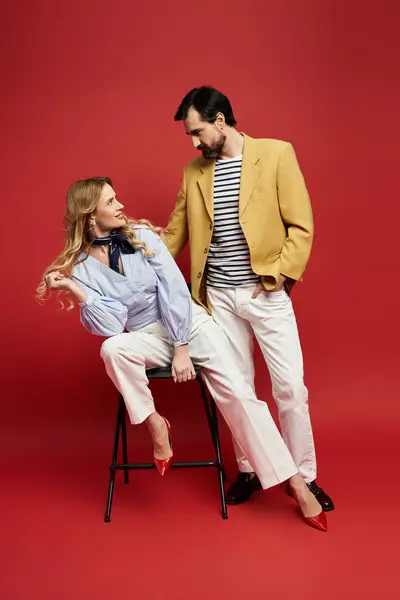 A smiling couple interacts playfully, showcasing modern elegance and fashion in their attire. — Stock Photo