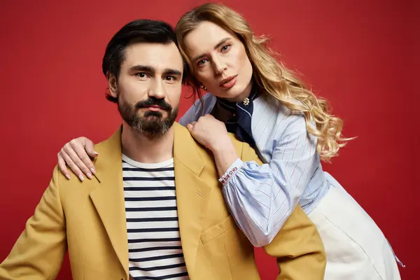 A middle aged couple is elegantly dressed, enjoying a confident pose together in a vibrant setting. — Stock Photo