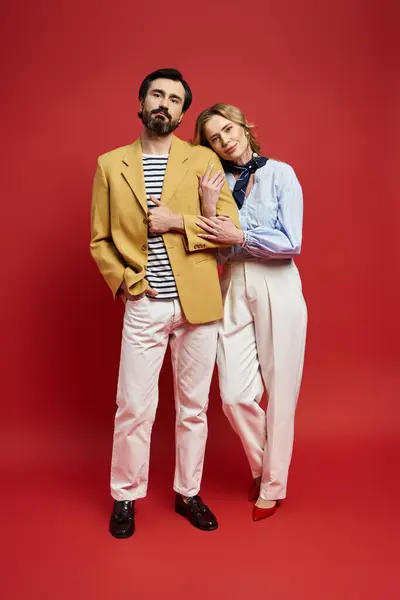 A middle aged couple stands closely together, exuding confidence and style in modern attire. — Stock Photo