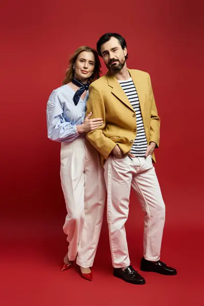 Una pareja elegante se mantiene estrechamente unida, mostrando atuendo moderno y un ambiente lúdico. — Stock Photo