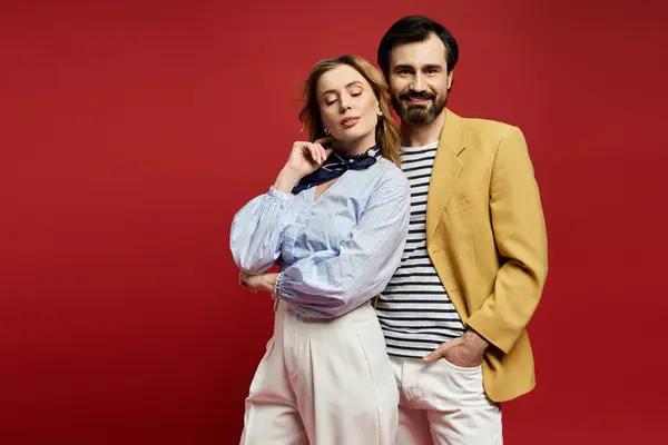 A middle aged couple shows off their style in chic outfits with a bold red backdrop. — Stock Photo