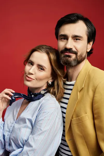 A stylish couple stands closely, smiling warmly while embracing their unique fashion choices. — Stock Photo