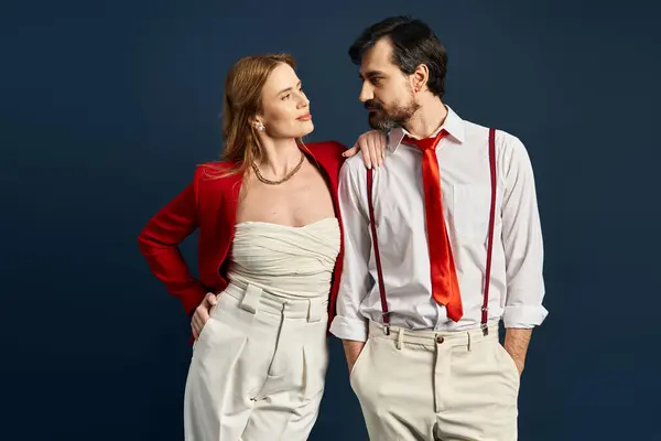 Una coppia di mezza età alla moda mostra eleganza e fascino in uno studio con uno sfondo sorprendente. — Foto stock