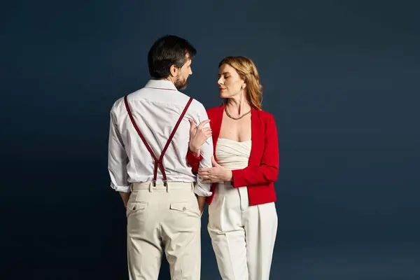 A middle aged couple stands close, lost in a moment of connection, showcasing elegant fashion. — Stock Photo