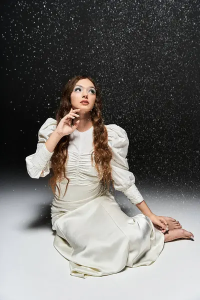The young woman gazes with curiosity as shimmering particles float gracefully around her. — Stock Photo
