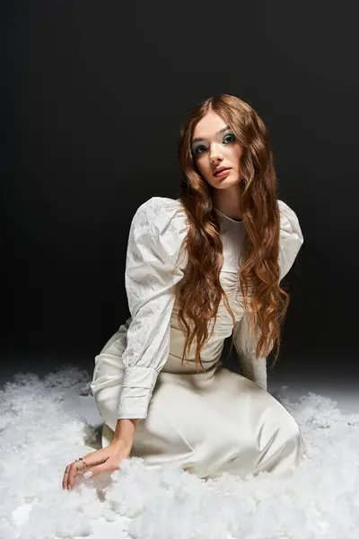 The stunning woman with flowing hair poses elegantly while surrounded by soft textures. — Stock Photo