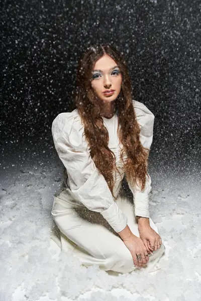 Die junge Frau mit wallenden Haaren, umgeben von sanftem Schneefall. — Stockfoto