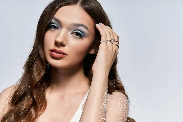 A jovem mulher deslumbrante mostra sua beleza com maquiagem cativante olho azul e uma pose graciosa. — Fotografia de Stock