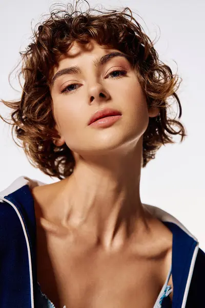 A young woman with curly hair captures the viewers attention with her intense expression and poise. — Stock Photo