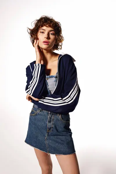 The young woman displays a thoughtful expression dressed in a trendy outfit with various layers. — Stock Photo