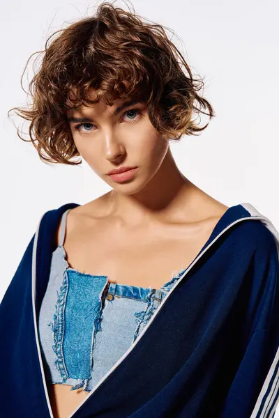 A young woman with curly hair expresses deep emotions while showcasing her trendy denim style. — Stock Photo