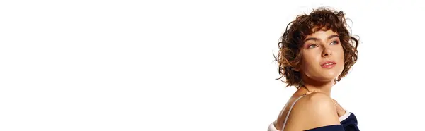A young woman with curly hair reflects her emotions against a plain backdrop, dressed elegantly. — Stock Photo