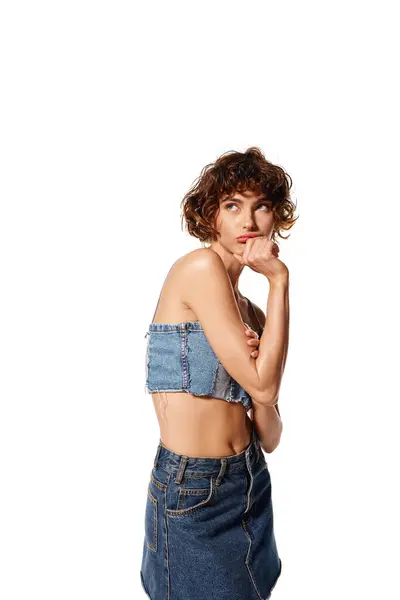 Die junge Frau drückt tiefe Emotionen aus, während sie ein stylisches Jeans-Outfit trägt. — Stockfoto