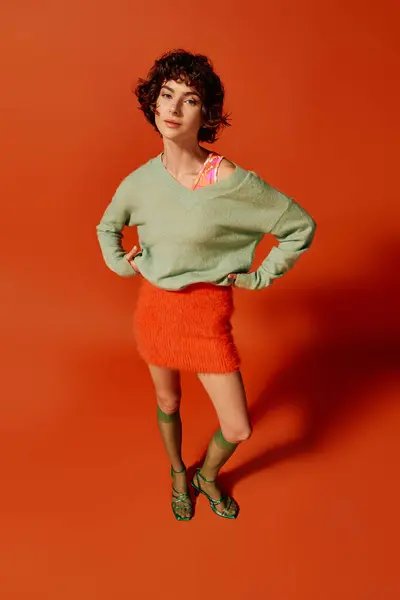 The young woman stands with poise, expressing emotion in a stylish, vibrant ensemble. — Stock Photo