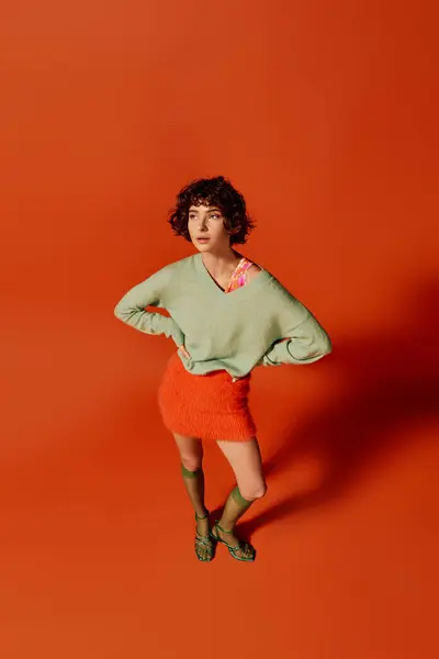 The young woman dressed in bright colors stands confidently with a thoughtful expression. — Stock Photo