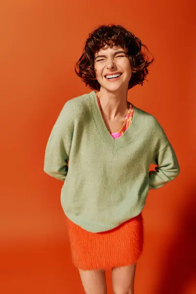 A young woman expresses joy while dressed in colorful attire, radiating happiness and style. — Stock Photo