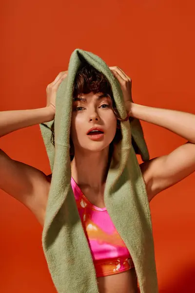 A young woman with a towel on her head showcases a range of emotions in a colorful setting. — Stock Photo
