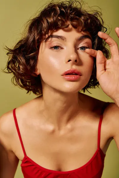Una giovane donna dai capelli ricci guarda lo spettatore, trasudando fiducia ed emozione. — Foto stock