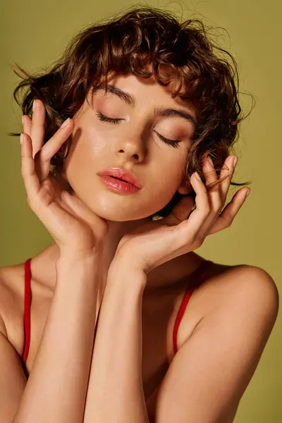 A young woman expresses deep emotion, gently holding her face, radiating tranquility and beauty. — Stock Photo