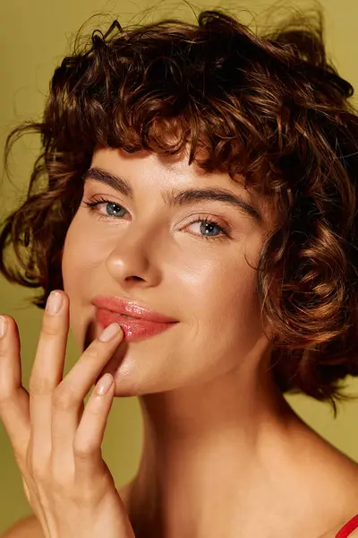 Una joven con rizos juguetones toca suavemente sus labios, mostrando un momento de corazón. — Stock Photo