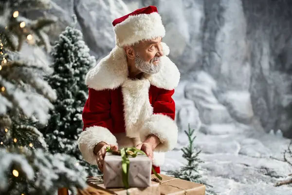 A cheerful figure in a red suit brings holiday joy by presenting a beautifully wrapped gift. — Stock Photo