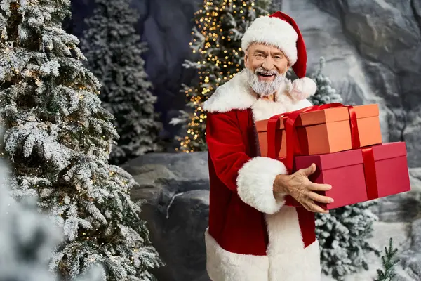 Papai Noel espalha alegria feriado enquanto carrega presentes brilhantes em meio a uma paisagem festiva. — Fotografia de Stock