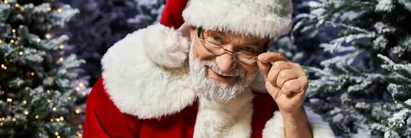 A cheery figure dressed as Santa Claus shares laughter and warmth in a snowy forest setting. — Stock Photo