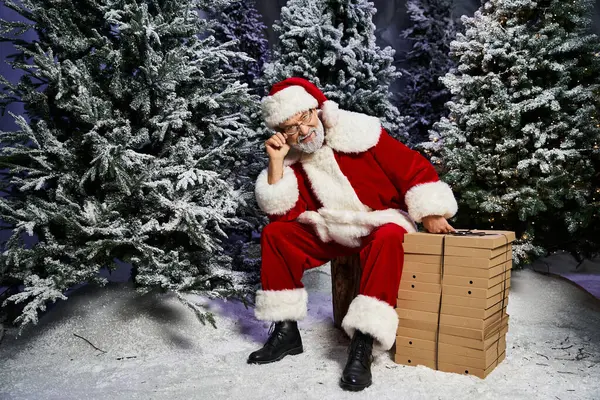Santa Claus sits on a log in the snow, readying for a joyful celebration. — Stock Photo