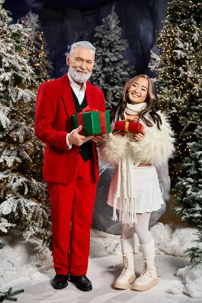 Two happy people share wrapped gifts in a joyful winter wonderland. — Stock Photo