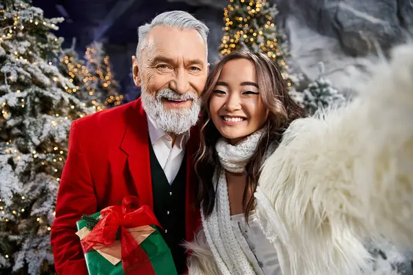 A cheerful moment captured among bright Christmas trees adorned with sparkling lights. — Stock Photo