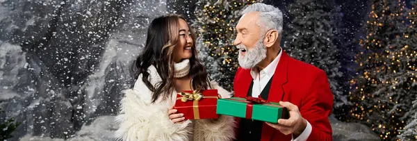 Deux personnes échangeant joyeusement des cadeaux colorés dans un beau fond enneigé. — Photo de stock