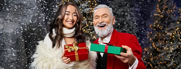 A warm gathering of friends sharing joy as they hold festive gifts in a snowy wonderland. — Stock Photo