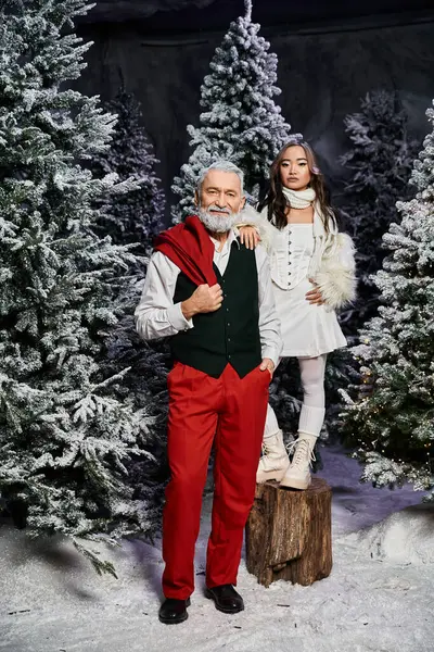 A heartwarming moment captures a grandfather and granddaughter enjoying Christmas in a snowy setting — Stock Photo