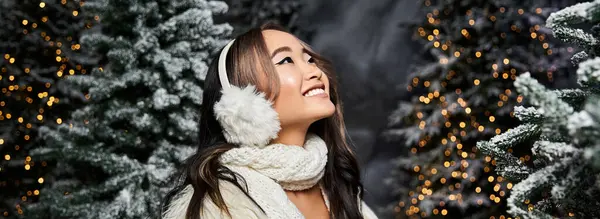 A joyful person revels in Christmas magic amid twinkling lights and snowy trees. — Stock Photo