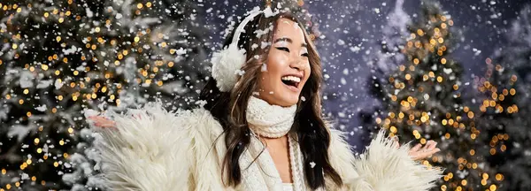 A young woman embraces the magic of Christmas, surrounded by soft snowflakes and twinkling lights. — Stock Photo
