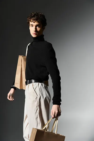 Um jovem bonito carrega sacos de compras, mostrando seu estilo elegante durante as festividades da Black Friday. — Fotografia de Stock