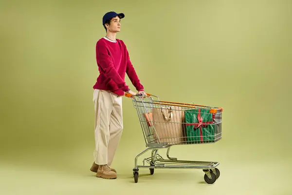 Um jovem elegante com cabelos encaracolados se diverte com a emoção da Black Friday, segurando sacos de compras. — Fotografia de Stock