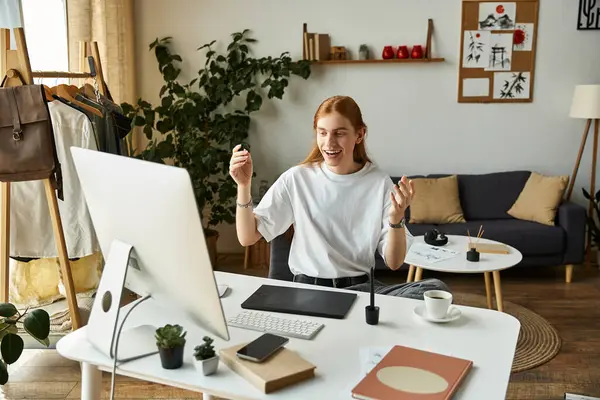 Un joven interactúa con entusiasmo con sus proyectos de diseño digital en una elegante oficina en casa. - foto de stock