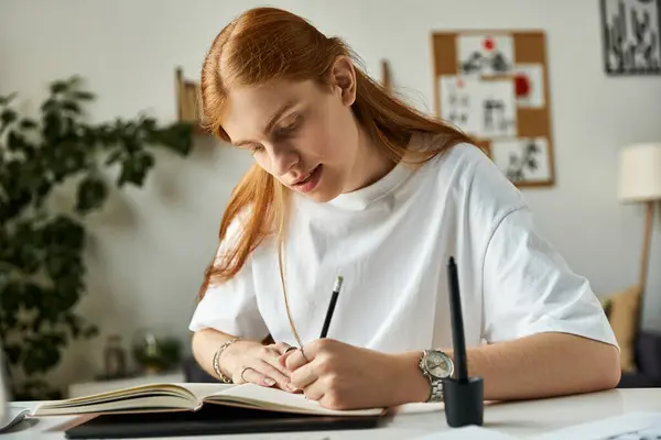 Ein junger Mann konzentriert sich intensiv auf sein Schreiben, umgeben von einem ruhigen und inspirierenden Arbeitsplatz. — Stockfoto