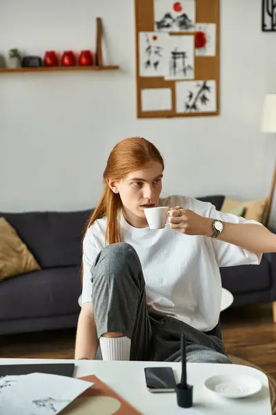 Relaxing at home, a young man enjoys his coffee in a stylish, comfortable space. — Stock Photo