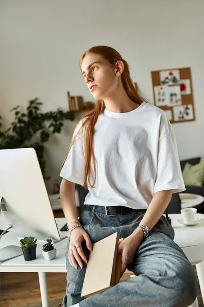 Um jovem de camisa branca contempla ideias em sua elegante mesa repleta de vegetação. — Fotografia de Stock