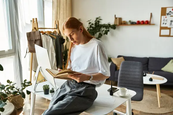 Engrossed in a book, a young man enjoys a peaceful moment in his stylish home. — Stock Photo