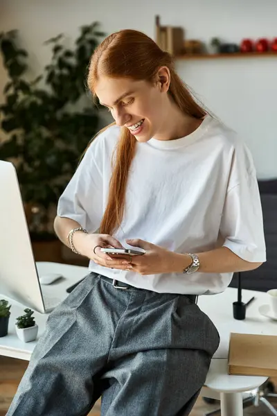 A young man wears a casual outfit and enjoys using his smartphone in a bright office. — Stock Photo