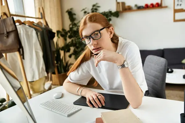 Engaged in reflection, a young man analyzes ideas while seated at a modern desk with plants. — Stock Photo