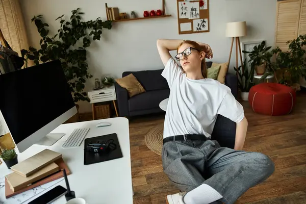 A young man stretches in a modern workspace filled with greenery and inviting furnishings. — Stock Photo