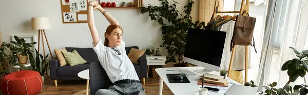 A young man relaxes with a stretch in a stylishly designed living room. — Stock Photo