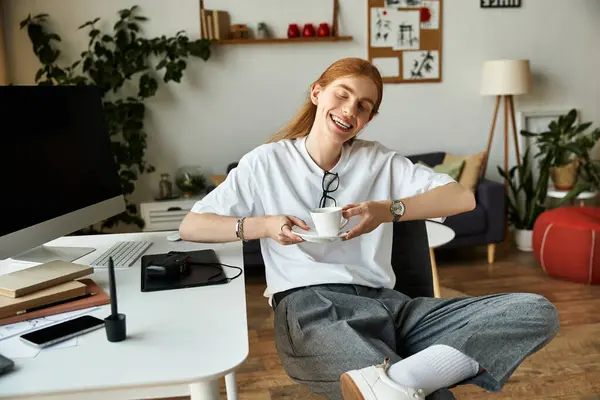 Questo giovane irradia gioia sorseggiando caffè in uno spazio di lavoro elegante e pieno di piante. — Foto stock